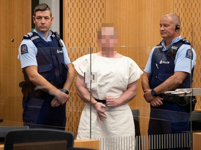 Brenton Tarrant makes a sign to the camera during his appearance in the Christchurch District Court.