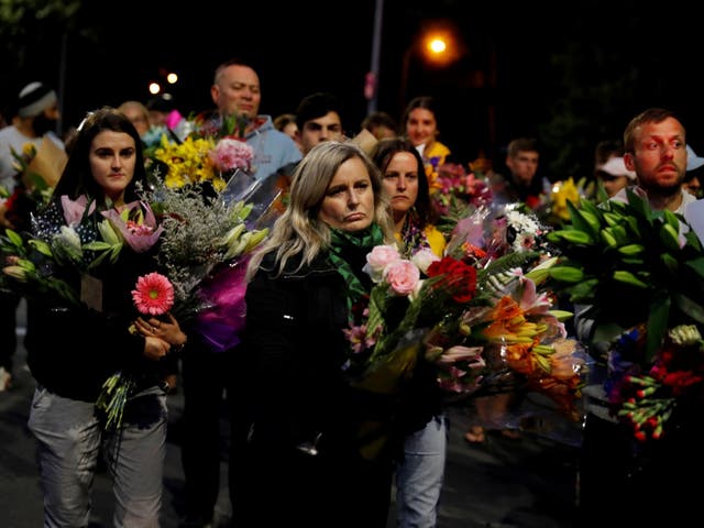 People lay flowers in tribute to the victims who were shot dead during two mosque attacks in Christchurch, New Zealand
