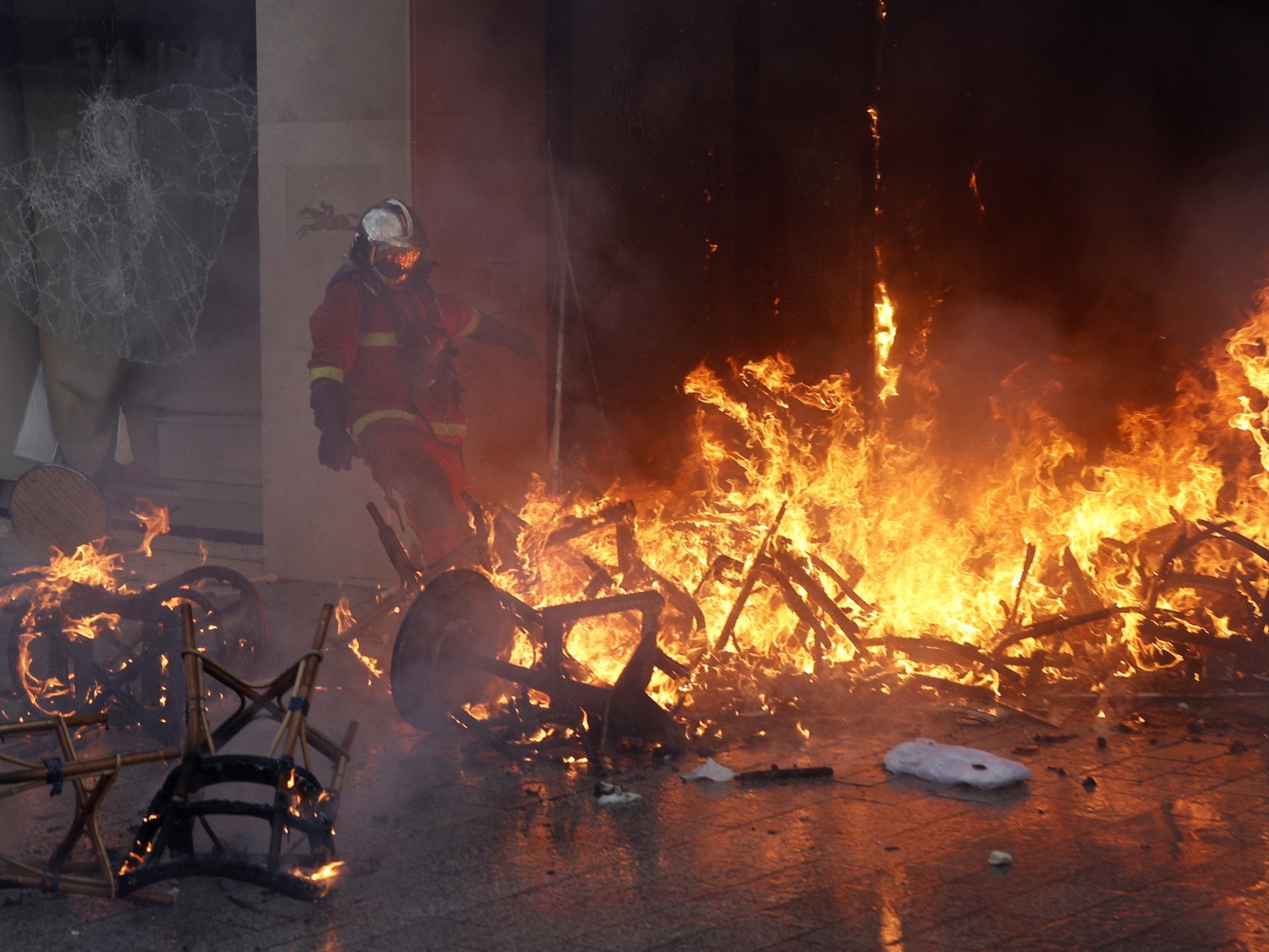Fireman tries to extinguish a blaze at a luxury store on the Champs Elysees