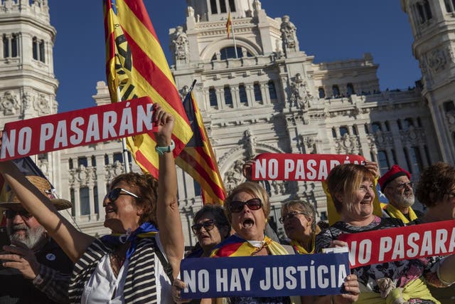 Catalan pro-independence demonstrators hold banners reading "shall not pass" and "there is no justice" during a rally in Madrid