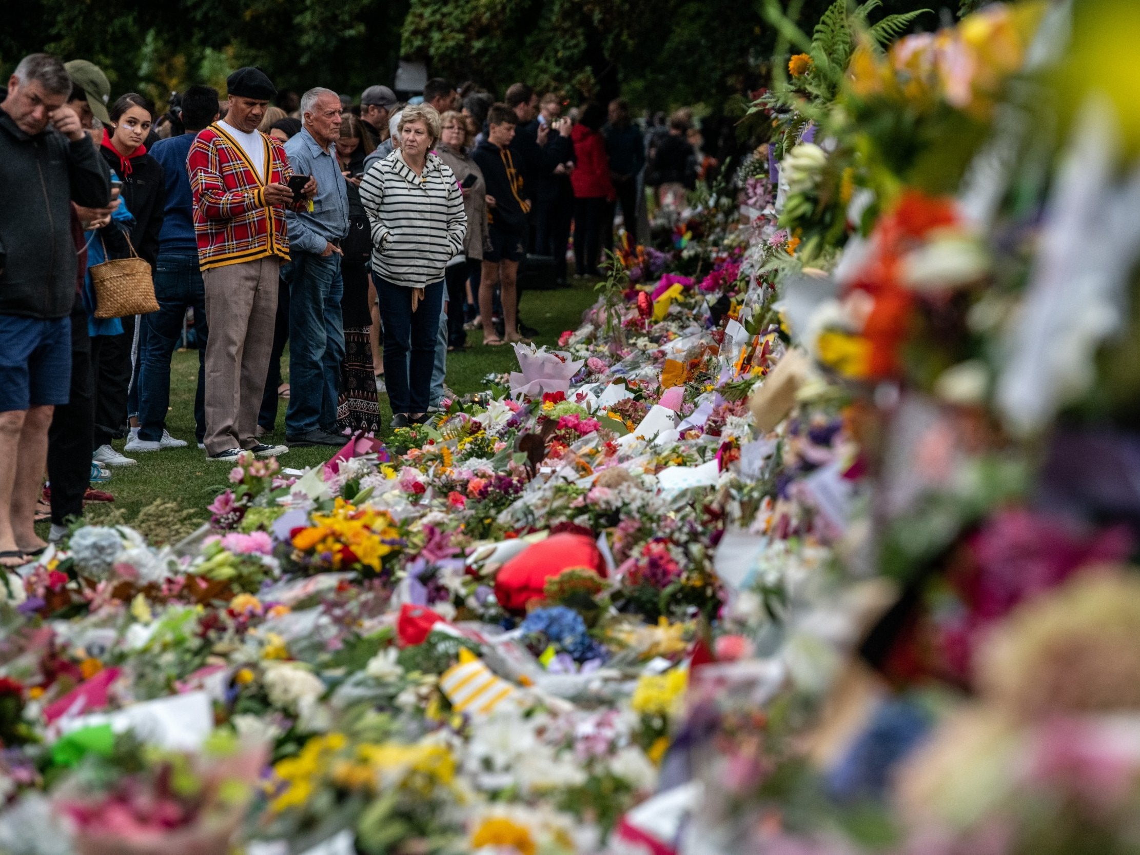 People leave flowers and tributes at the Botanic Gardens in Christchurch after the mosque shooting