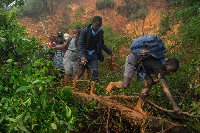 Students of St Charles Lwangwa school in Chimanimani, eastern Zimbabwe, make their way past a mudslide caused by cyclone Idai