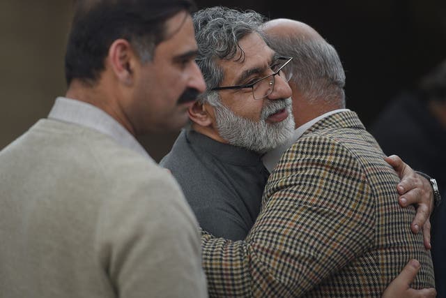 Pakistani peoples embrace with Rizwan Rashid (C), elder brother of Pakistani national Naeem Rashid, who was killed in the attacks to the Christchurch mosques