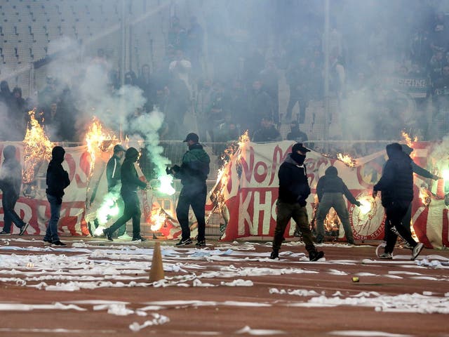 <p>Fans burn a banner in front of stands during a Greek Super League soccer match inside the Athens' Olympic stadium, in Athens, Sunday, March 17, 2019</p>