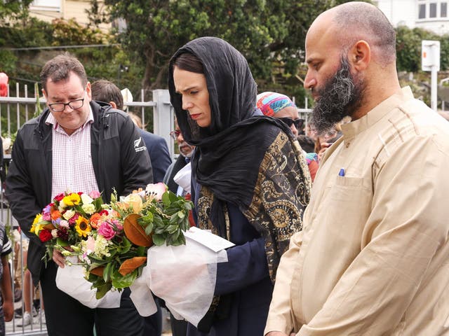 Prime minister Jacinda Ardern lays flowers while finance minister Grant Robertson looks on at the Kilbirnie Mosque