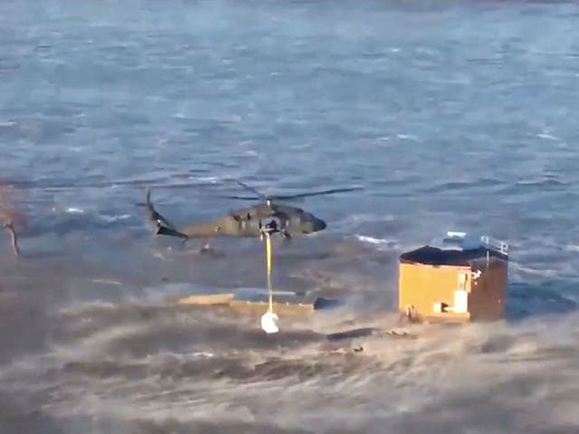 National Guard helicopters drop bales of hay for cattle isolated by floods