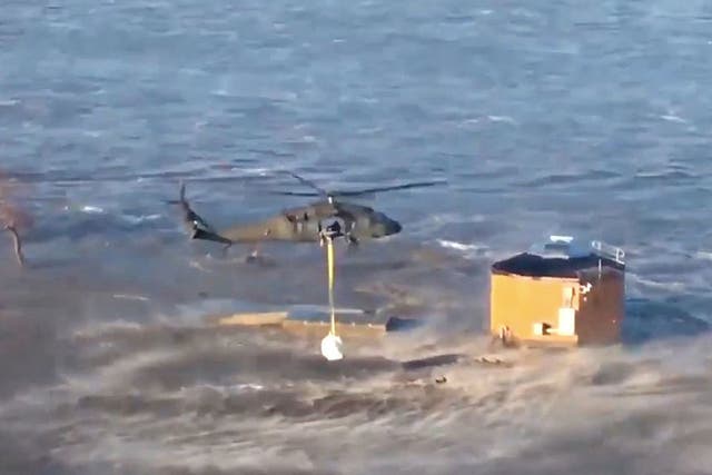 National Guard helicopters drop bales of hay for cattle isolated by floods
