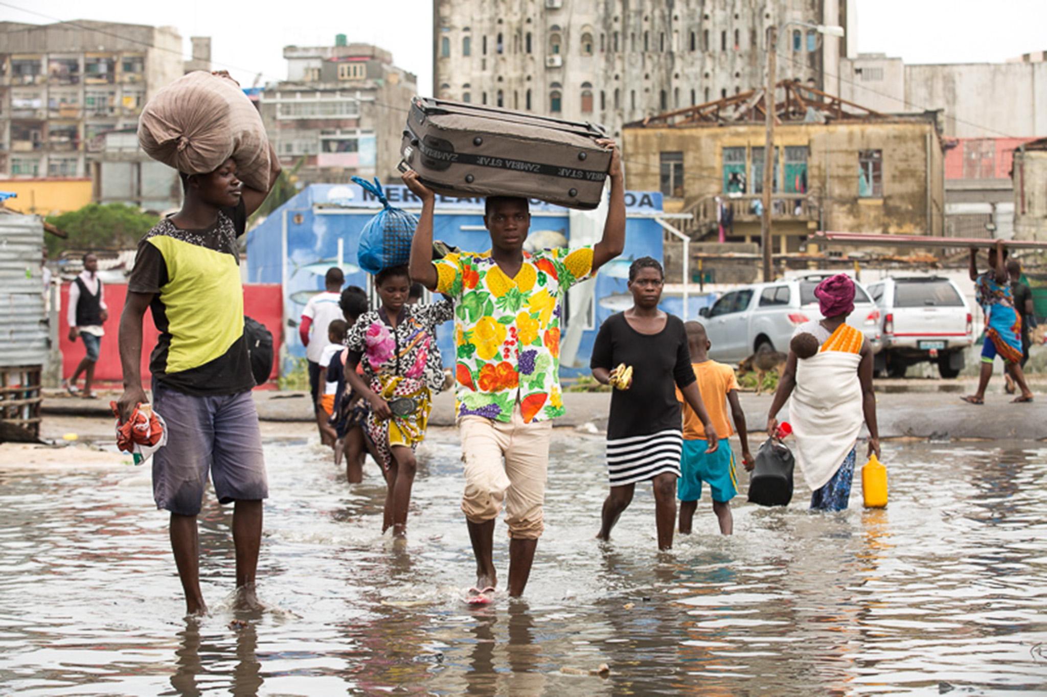 Residents of Beira in Mozambique carry their belongings through floodwater this week
