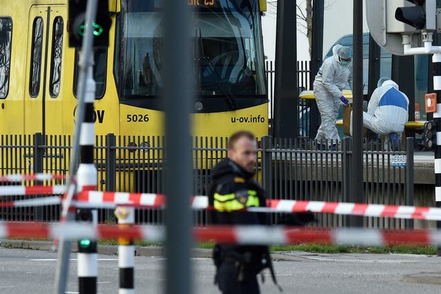 Policemen and rescuers are at work, on March 18, 2019 in Utrecht, near a tram where a gunman opened fire killing at least three persons and wounding several