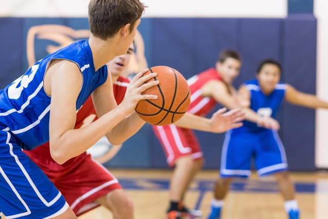 Boys high school basketball team: player about to shoot over defender
