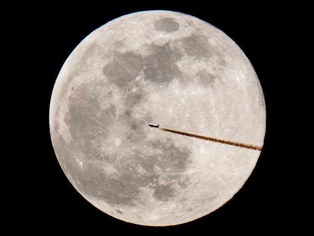 An airplane silhouettes against the supermoon on 19 February, 2019 in Nuremberg, southern Germany