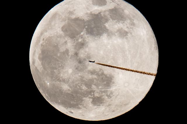 An airplane silhouettes against the supermoon on 19 February, 2019 in Nuremberg, southern Germany