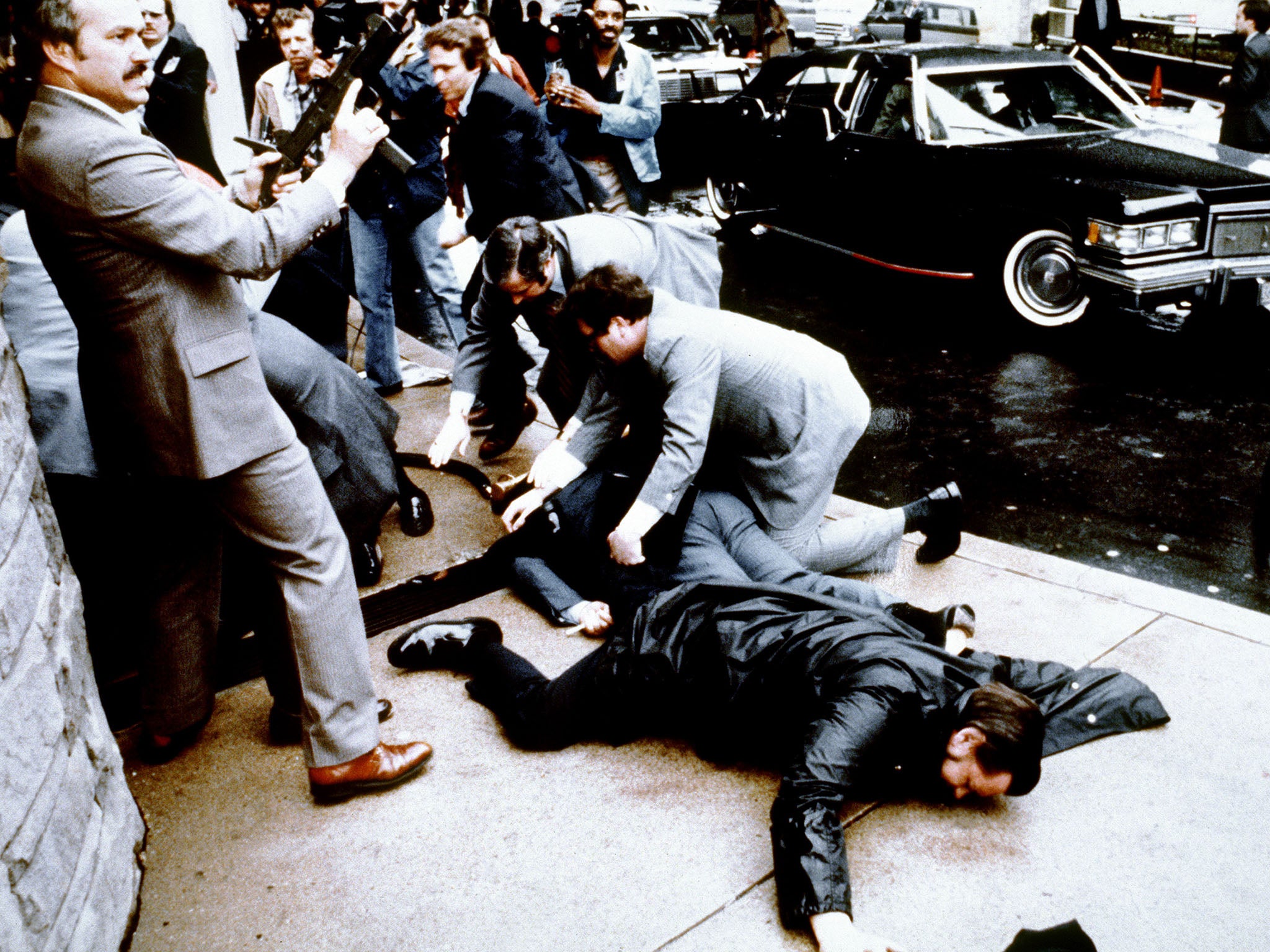 Police and secret service agents react during the assassination attempt on Ronald Reagan in 1981