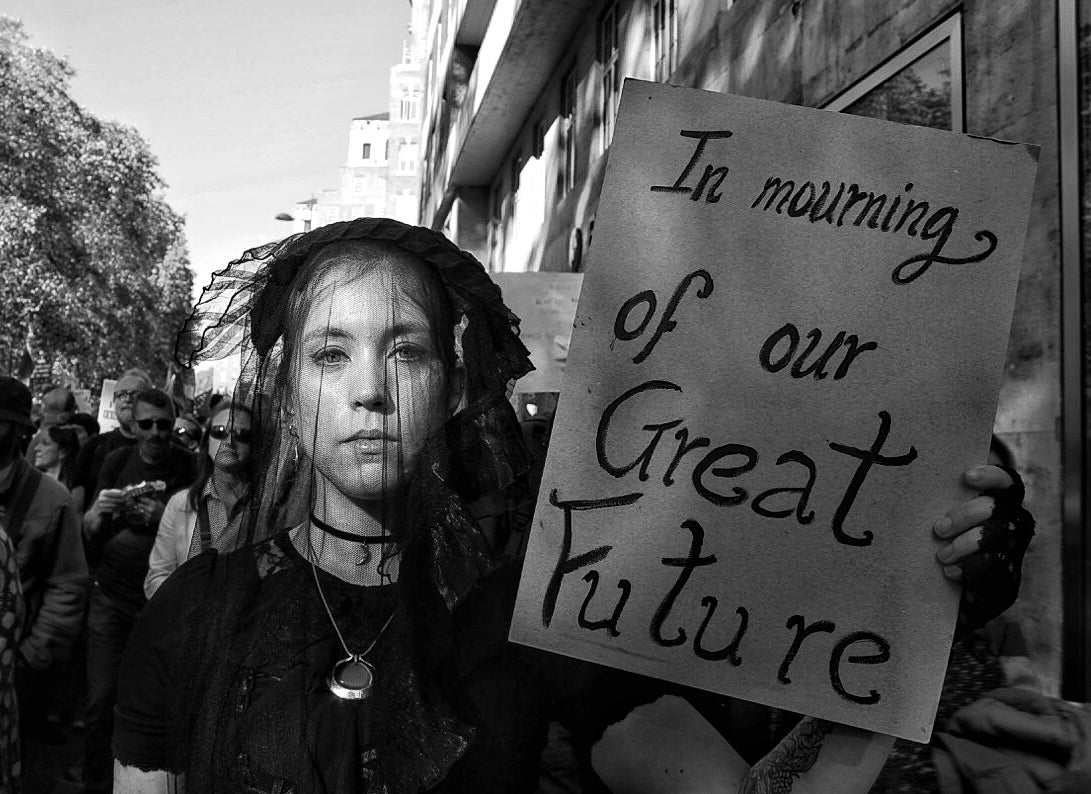 Anti-Brexit protester dressed as widow holds a sign in mourning of the future