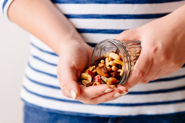 Hands holding a jar of nuts and dried fruits