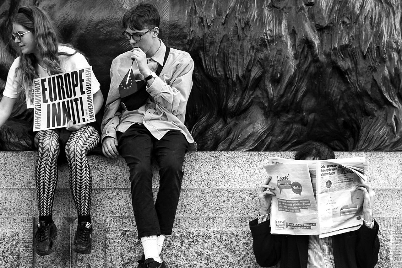 Remain protesters with pro-EU banners sit next to a Leave campaigner in Trafalgar square during the People’s Vote march in London. The pro-Brexit protester holds aloft the back cover of a newspaper to show his opposition to the Peoples Vote campaign