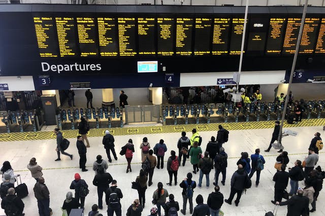 Late again: outbound travellers wait for information at London Waterloo station