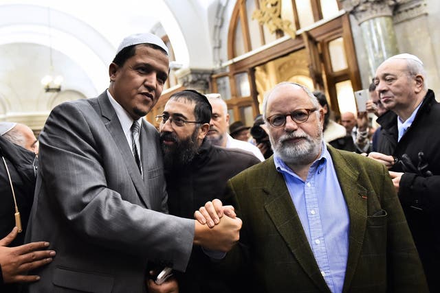 Imam of the Drancy Mosque, Hassen Chalghoumi (L) shakes hands with Samuel Sandler (C), father and grandfather of three of the victims of French jihadist gunman Mohamed Merah, during a ceremony for the victims of deadly attacks at the Grande synagogue in 2015.