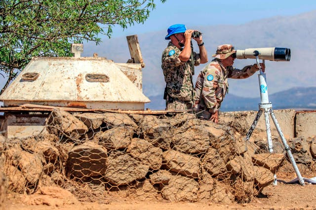 Members of the UN peacekeeping force look towards the Syrian side of Golan Heights