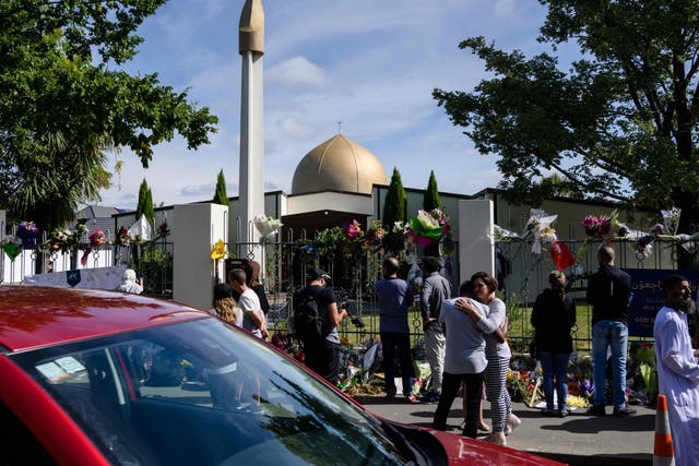 People gather outside the Al Noor Mosque after the main road that runs alongside it was opened to traffic in Christchurch on March 23, 2019. - Muslims prayed at Christchurch's main mosque for the first time since a white supremacist massacred worshippers there as New Zealand sought to return to normality after the tragedy.