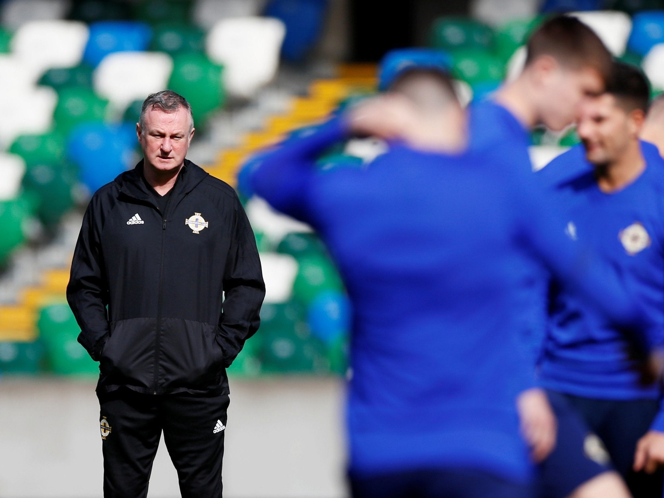 Michael O'Neill watches his side train inside Windsor Park