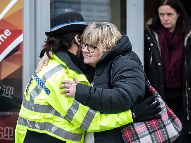 Lisa Squire, the mother of missing student Libby, hugs a police officer after leaving a church service in Hull