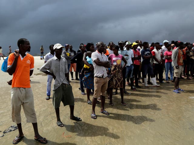 Relatives and friends watch as the boat arrives from Buzi disembark from a boat after being rescued from a flooded area of Buzi district, 200km outside Beira, Mozambique, Saturday 23 March 2019.