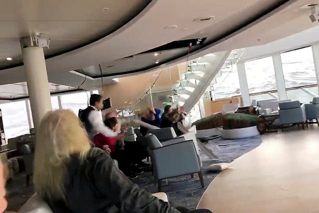 Passengers protect themselves from a collapsing ceiling as the cruise ship Viking Sky lists