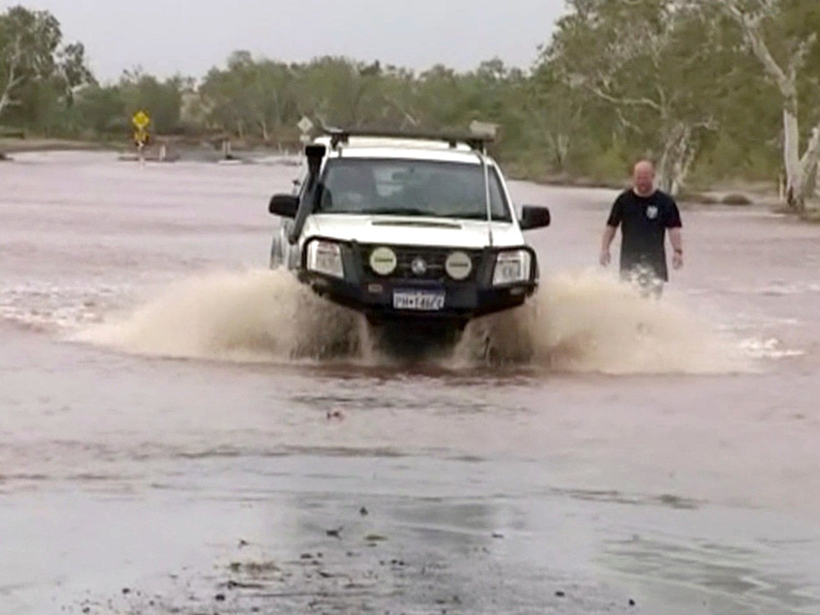 A car drives through a flooded road in Port Hedland, Western Australia, 25 March 2019 after Cyclone Veronica hit coastal regions.