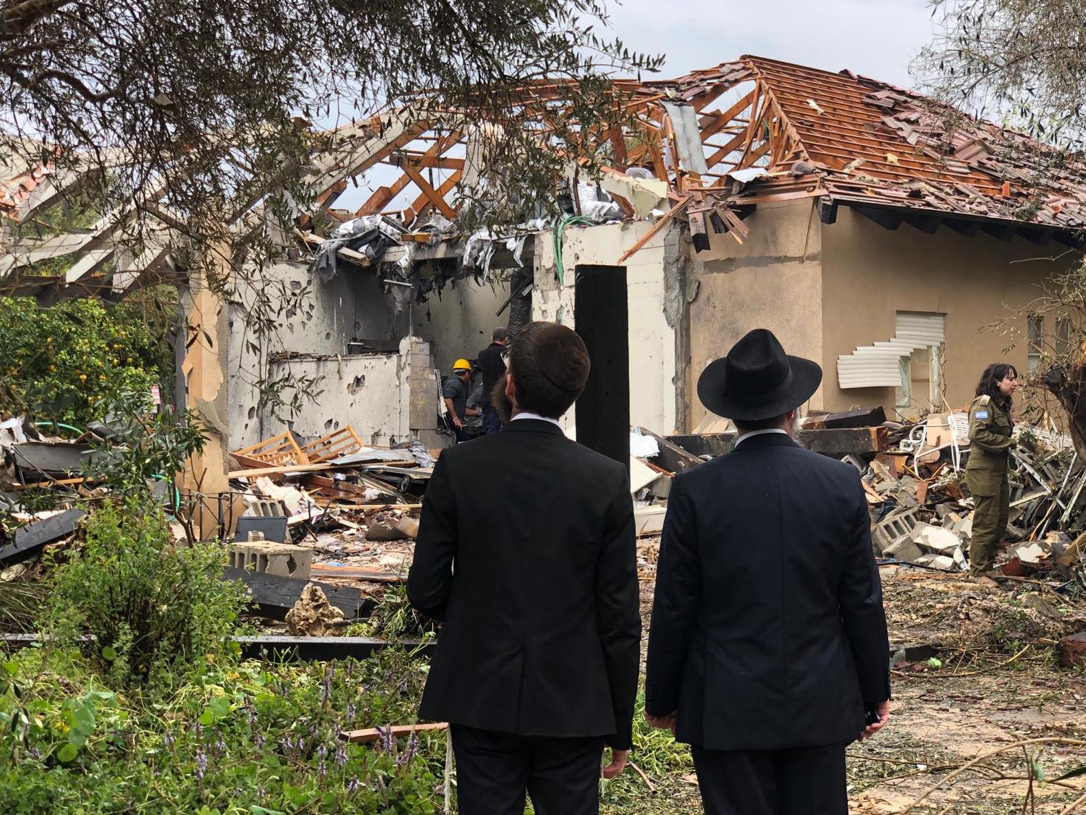 Locals look at the damage from the rocket attack