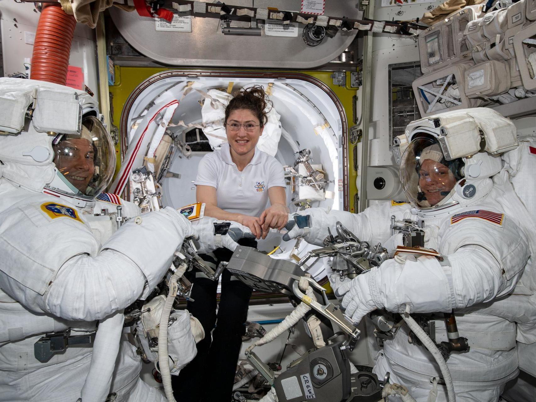 NASA astronaut Christina Koch (centre) assists fellow astronauts Nick Hague (left) and Anne McClain in their US spacesuits shortly before they begin a spacewalk