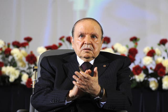 Algerian President Abdelaziz Bouteflika, sitting in a wheelchair, applauds after taking the oath as president in 2014