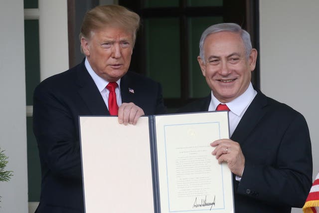 Trump and Netanyahu hold up a proclamation recognising Israel’s sovereignty over the Golan Heights (