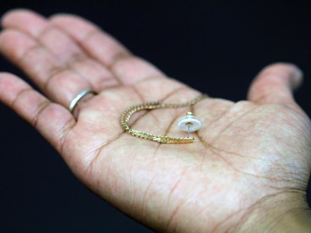 An earring is shown paired with a transdermal patch backing. The white ring is the patch containing the contraceptive hormone