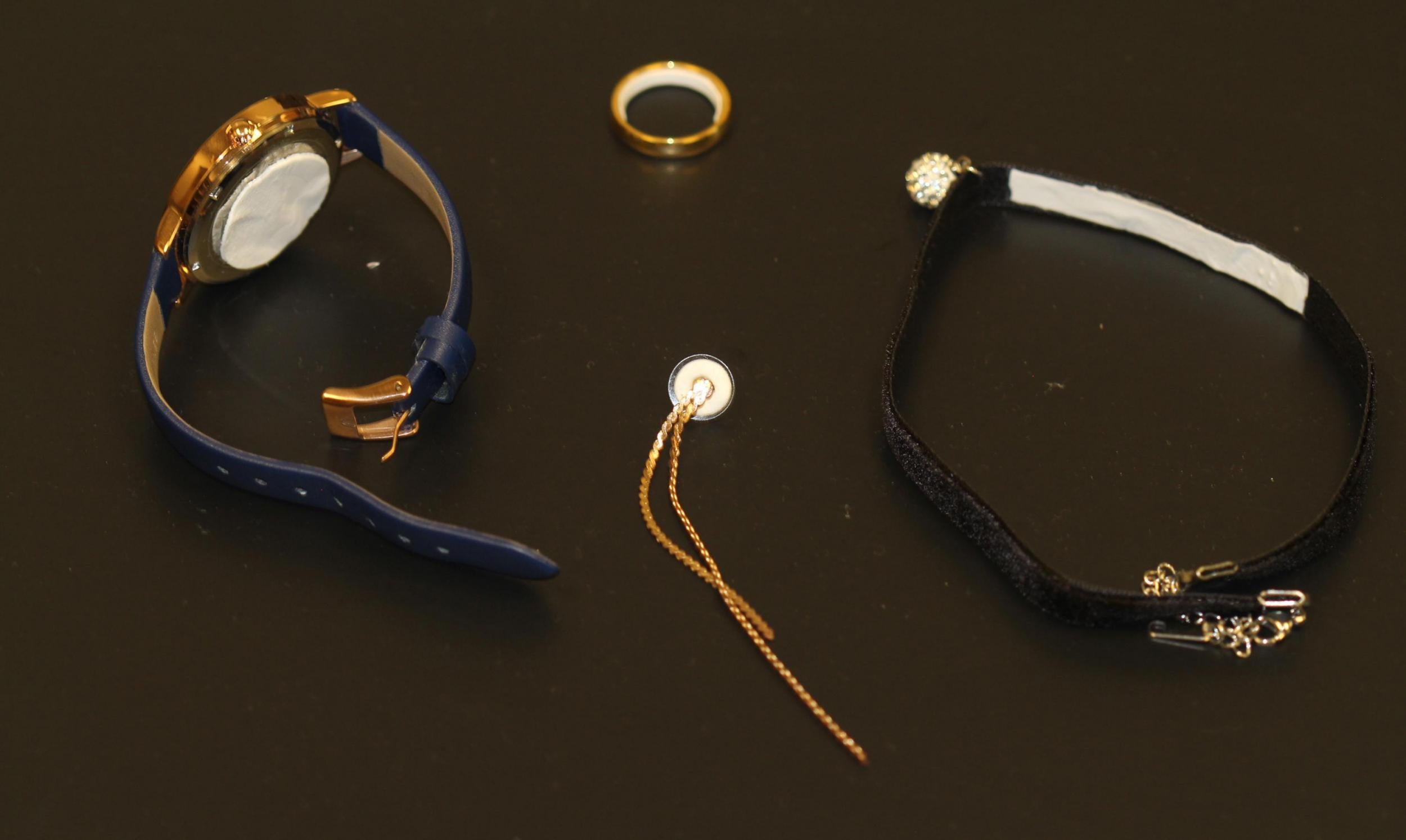 Image shows potential contraceptive jewellery, in clockwise order, a pharmaceutical watch, ring, choker necklace and earring. In each case, a white contraceptive patch material is applied to a part of the jewellery that would be in contact with the skin.