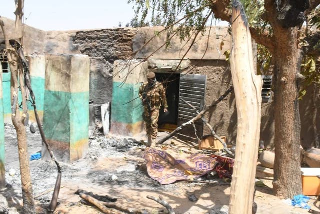 A soldier walks amid the damage after an attack by gunmen on the Fulani village in Ogossagou, Mali