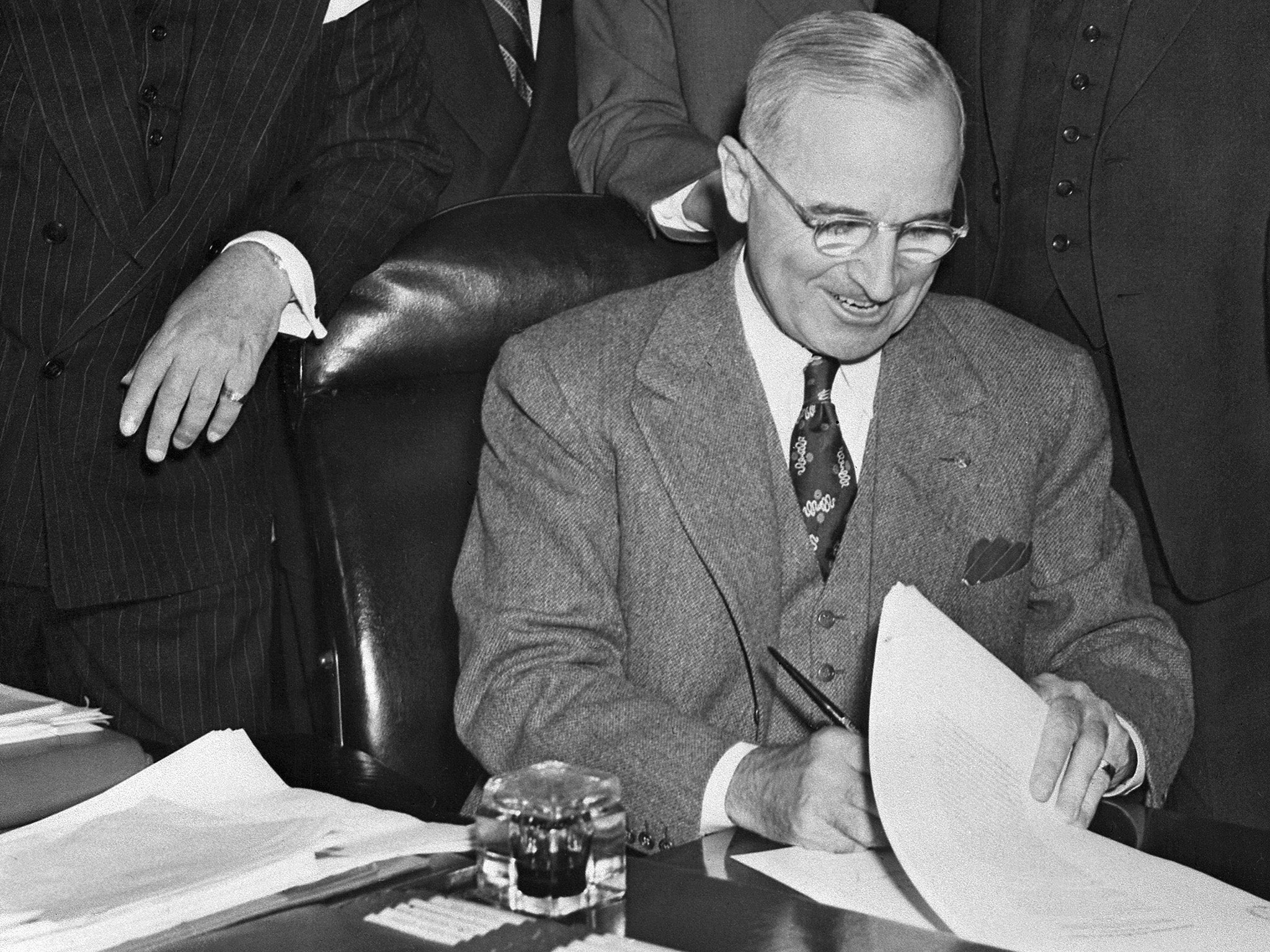 Harry Truman signs the Marshall Plan into effect on 3 April 1948