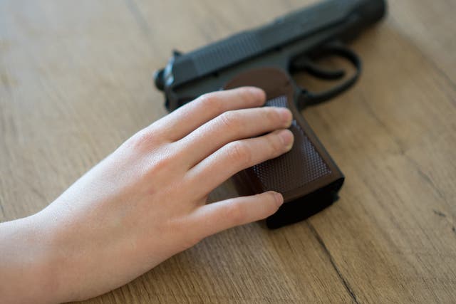 File image of child holding handgun.