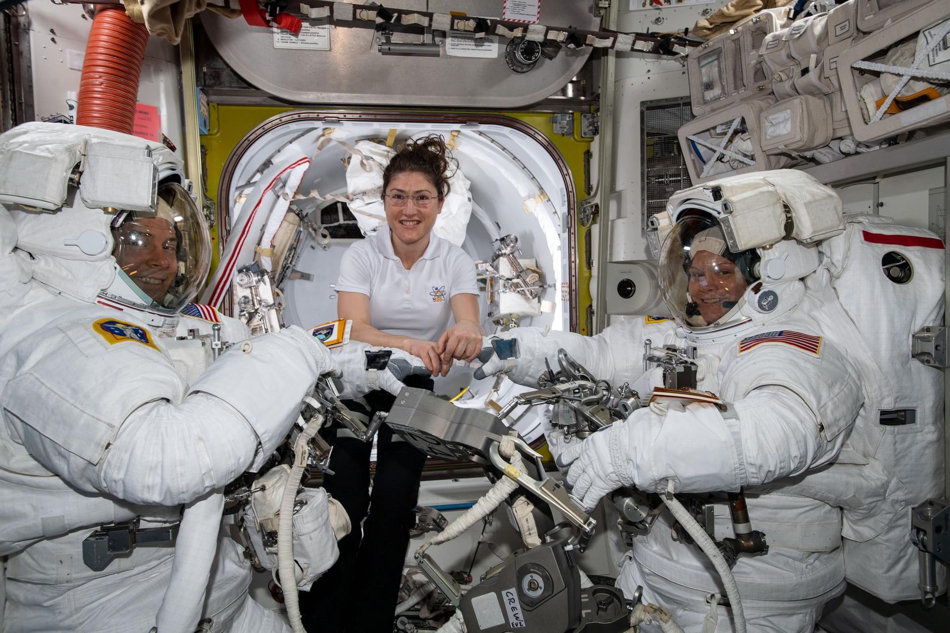 Nasa astronaut Christina Koch assist fellow astronauts Nick Hague and Anne McClain in their US spacesuits shortly before they begin the first spacewalk of their careers
