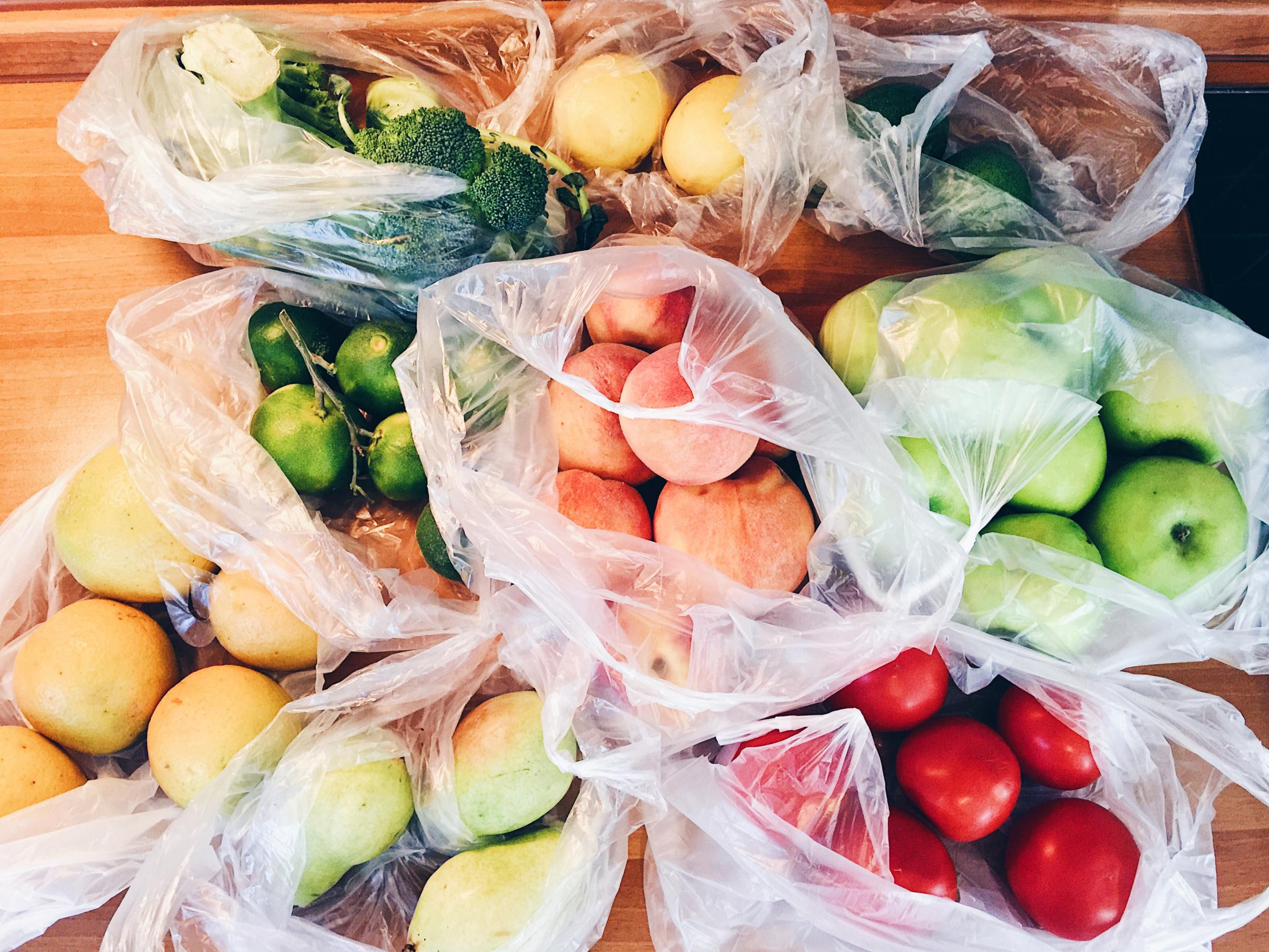 Apples, peachs, tomatoes, pears, cucumbers, avocado packed in plastic bags after shopping