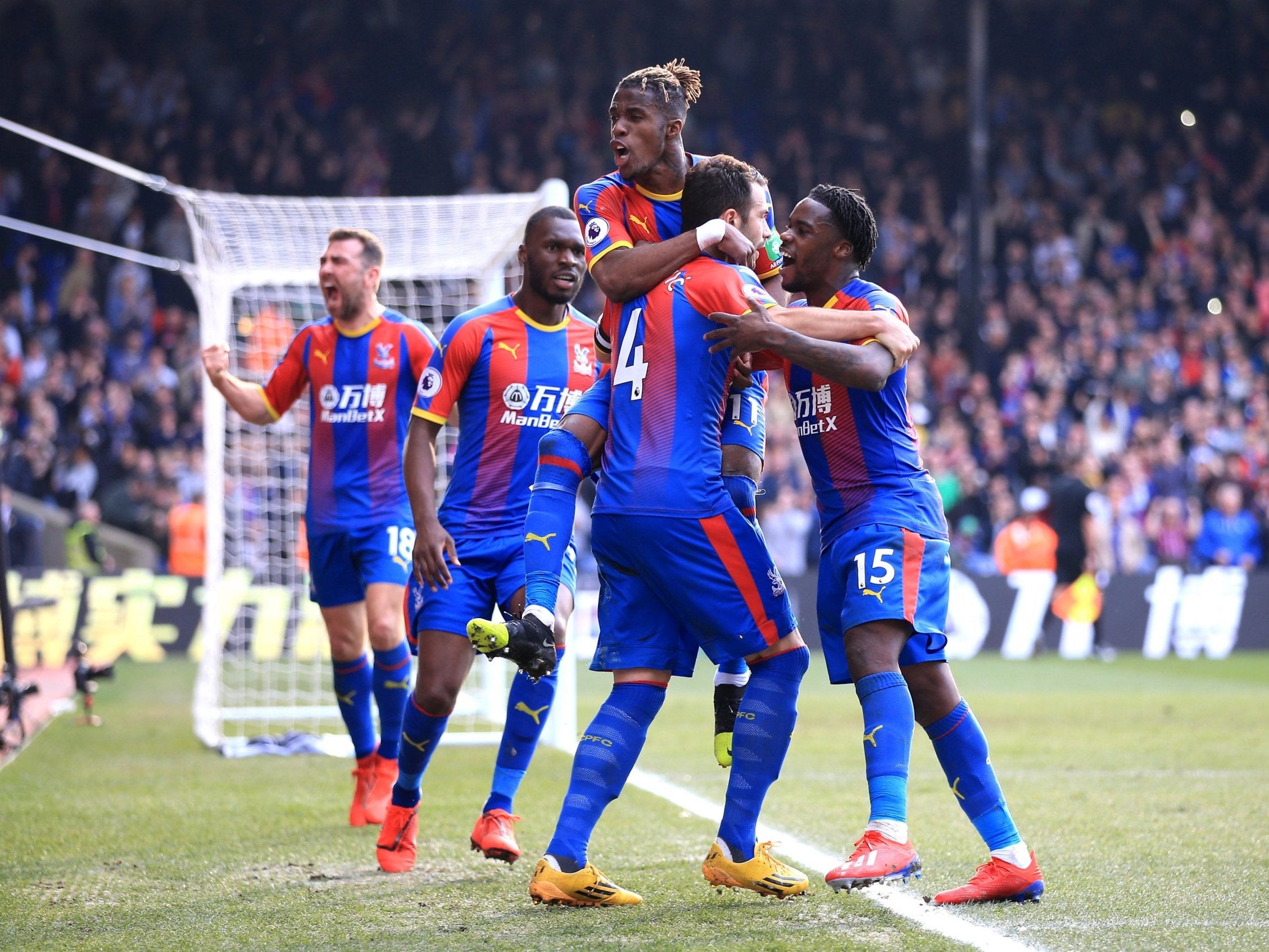 Wilfried Zaha leaps onto Luka Milivojevic to celebrate Palace's opening goal