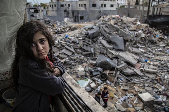 Walid’s niece Nour, 9, looks out at the destroyed remnants of her home after the latest bombings