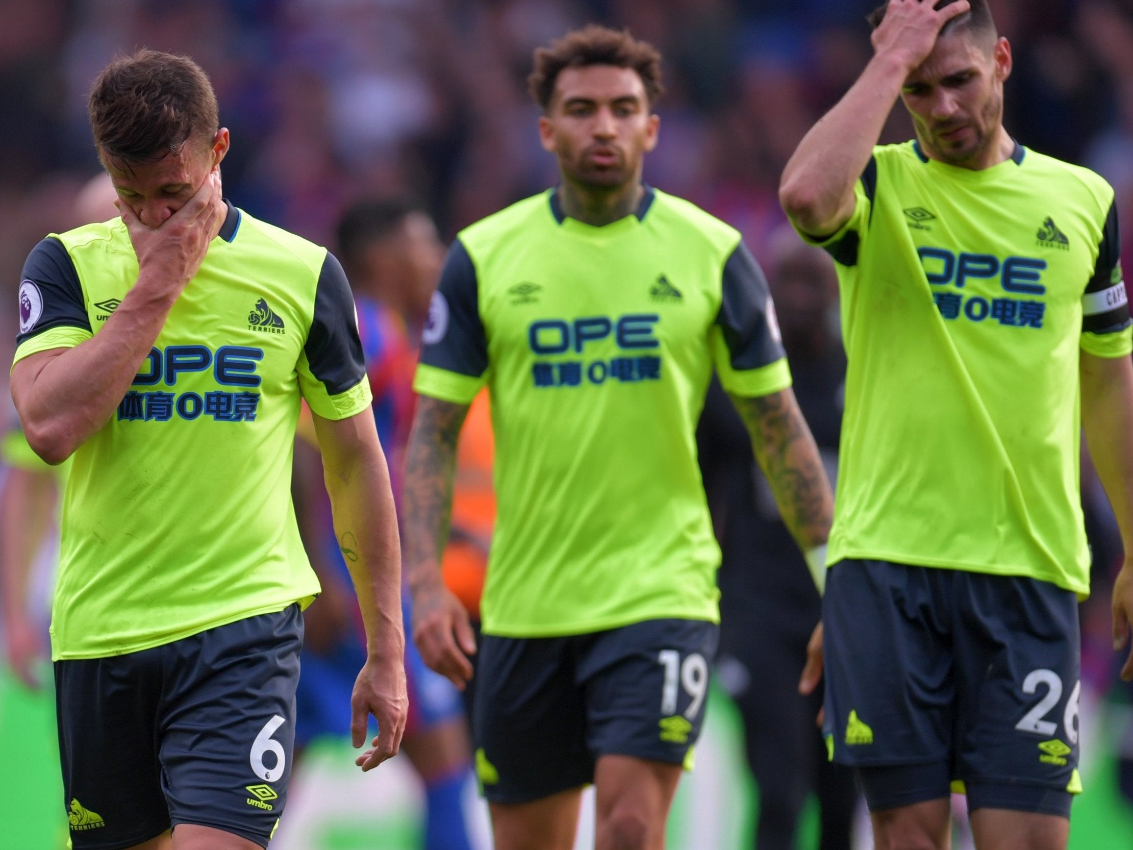 Huddersfield’s players leave the field dejected