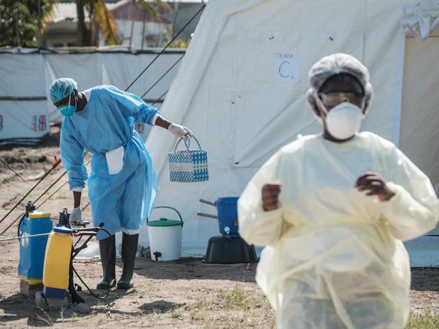 Medical staff disinfects the bag of a patient who has diarrhoea beside treatment tents at Macurungo urban health center in Beira
