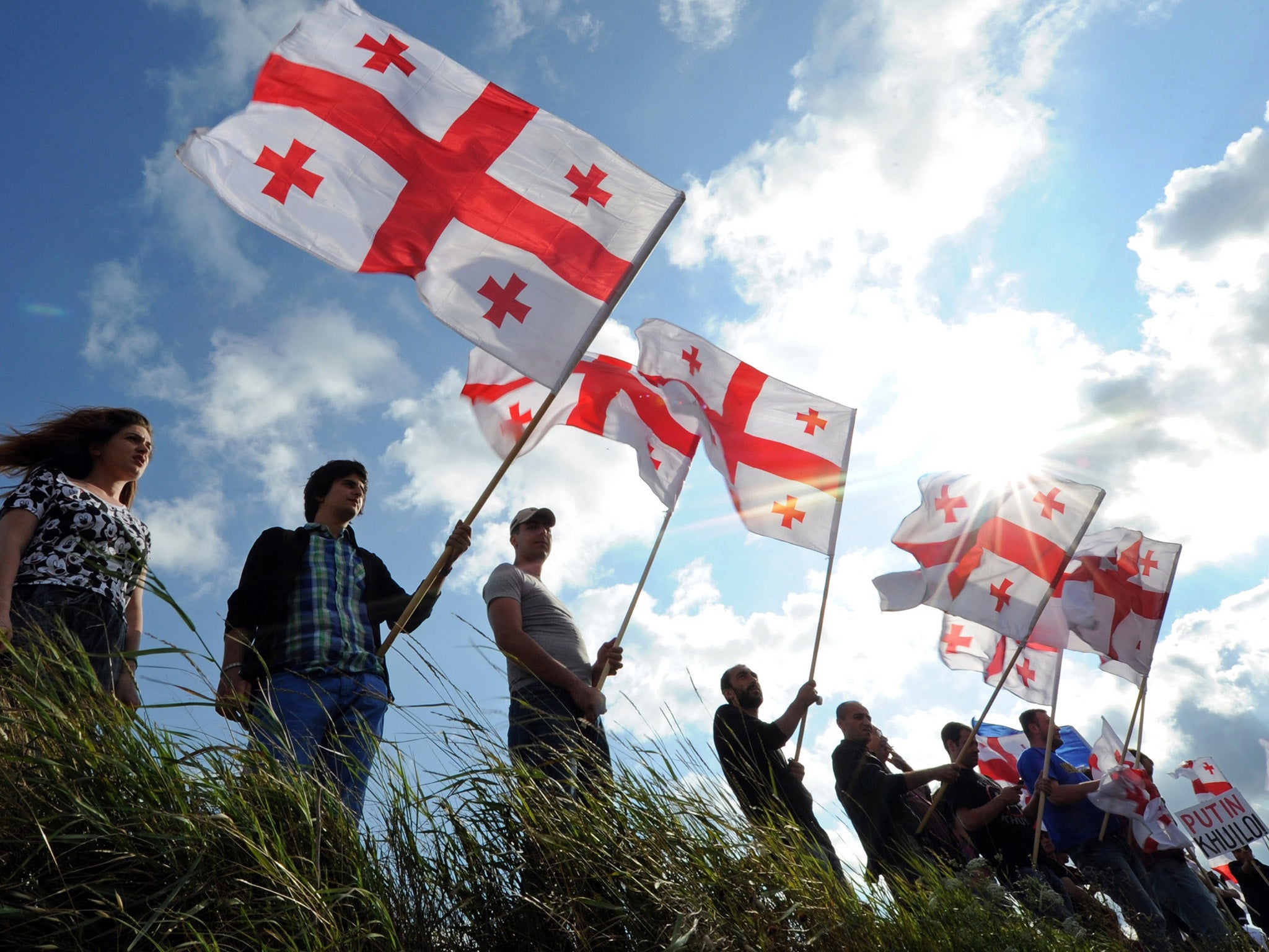 Members of Georgian NGOs wave the national flag to protest against a ‘de facto annexation’ by Russia of South Ossetia (AFP/Getty)