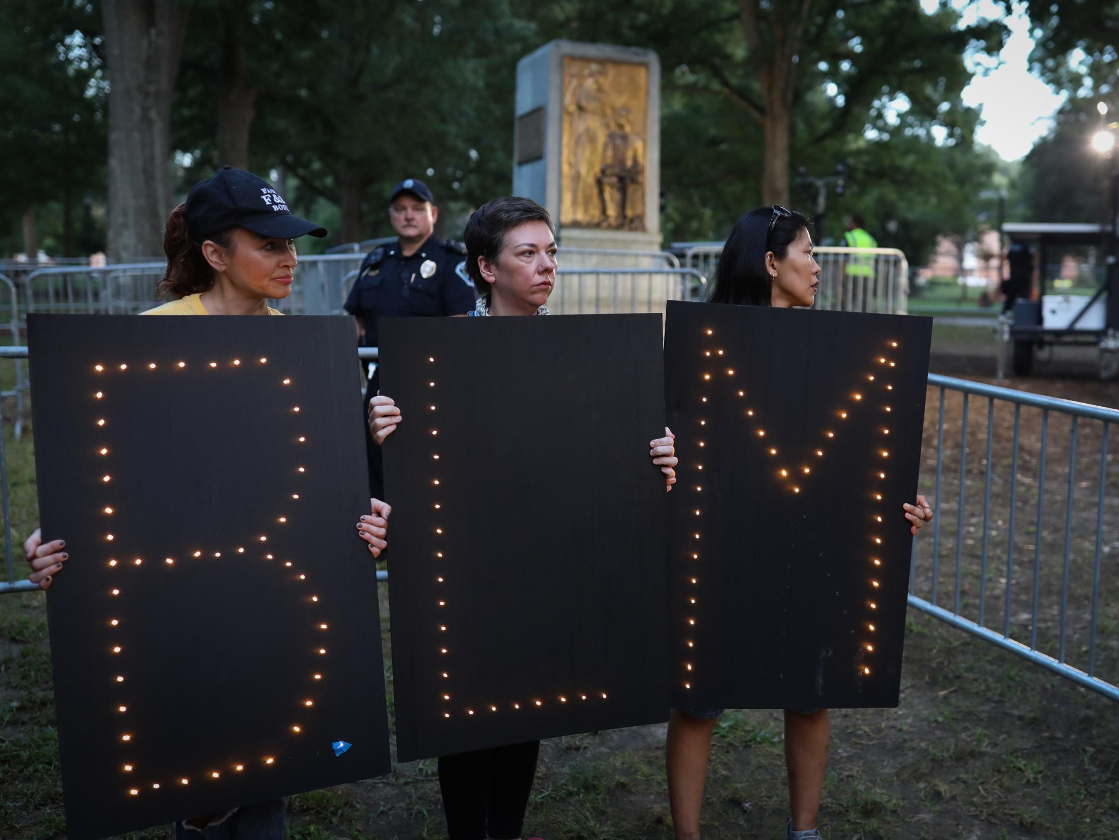 Protestors stand in front of where the Silent Sam statue once stood, metres away from where the Unsung Founders Memorial was defaced on Sunday