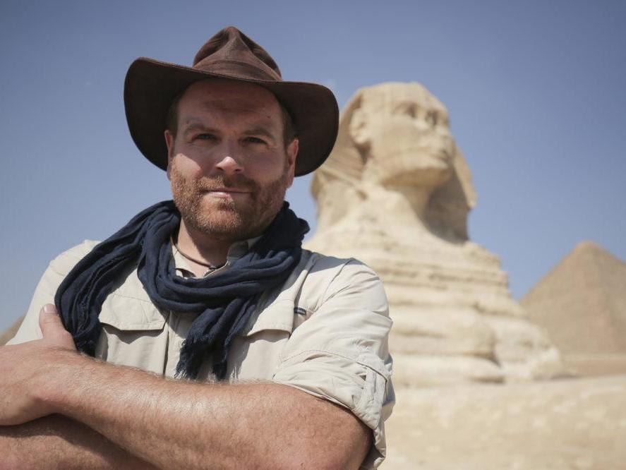 Host Josh Gates posing in front of the Great Sphinx of Giza in Egypt