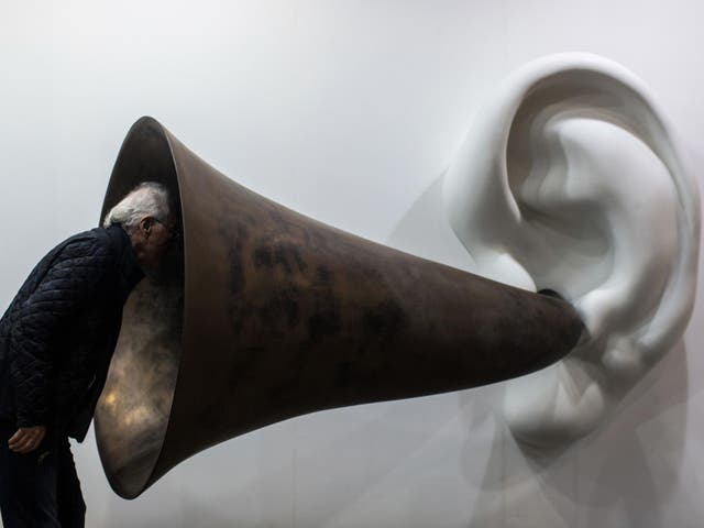 A visitor peers into US artist John Baldessari's "Beethoven's Trumpet (With Ear) Opus # 133" at the Art Basel fair in Hong Kong