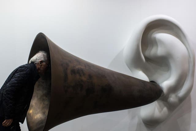 A visitor peers into US artist John Baldessari's "Beethoven's Trumpet (With Ear) Opus # 133" at the Art Basel fair in Hong Kong