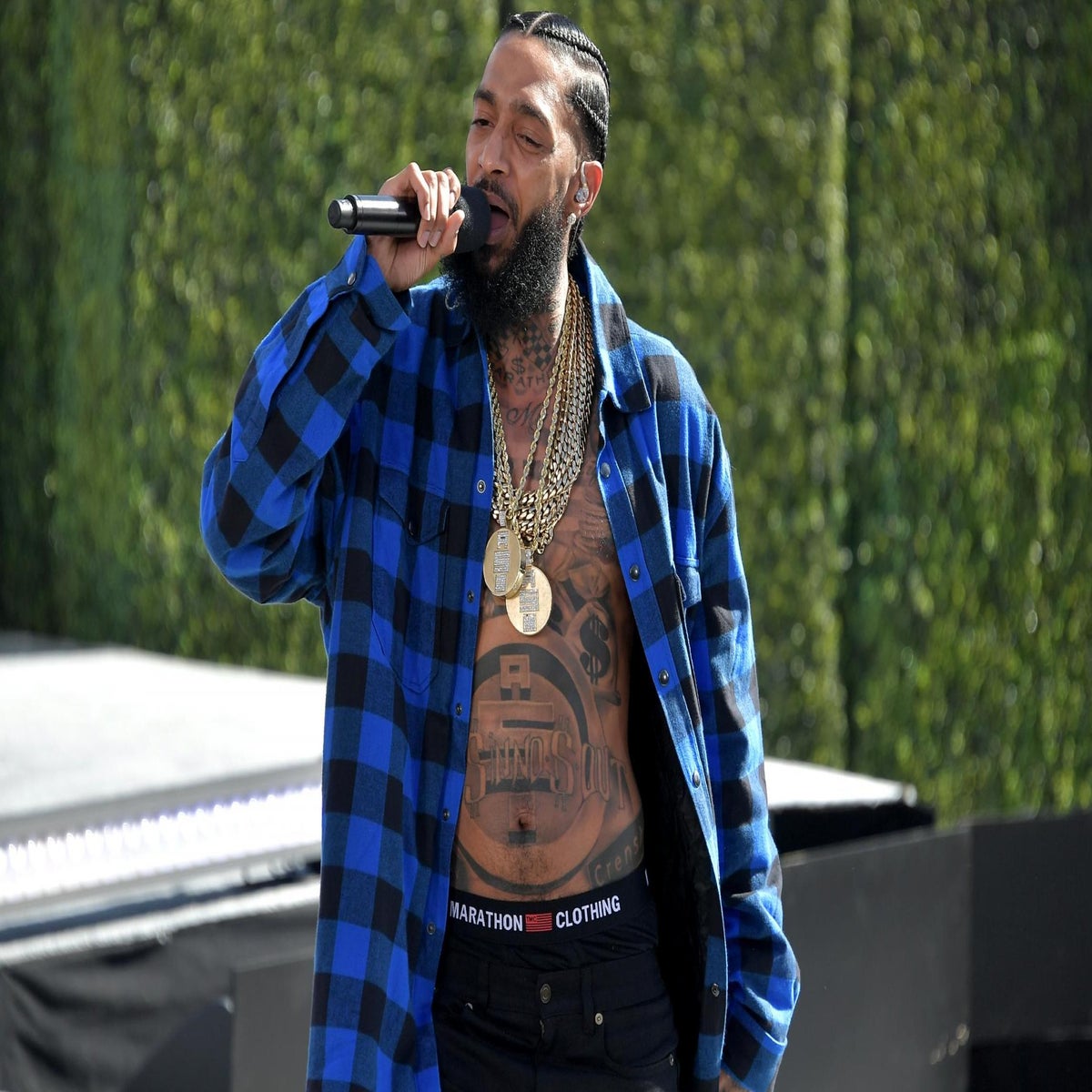 A fan of rapper Nipsey Hussle holds a sign as he attends a public